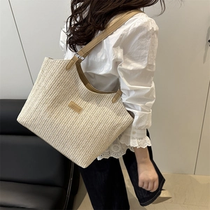 Elegant off-white straw tote bag with brown leather handles for casual summer outings