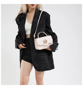 Vue détaillée du sac à main en cuir crème avec boucle dorée en M et poignée supérieure