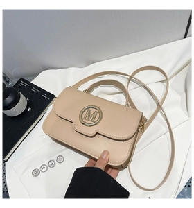 Détail du sac à main en cuir PU mat abricot avec logo M doré et fine bandoulière