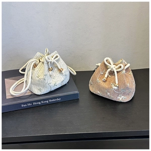 Detailed view of hand-woven bucket bags with floral embroidery and drawstring closure