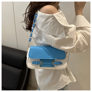 Detail of blue and white color-block shoulder bag with acrylic chain and buckle design