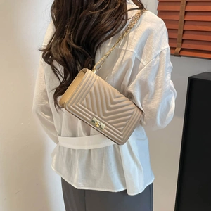 Chic beige quilted shoulder bag with golden chain strap shown in a stylish back view