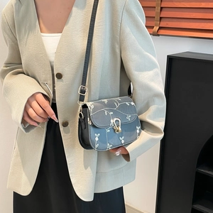 Sac à bandoulière bleu avec broderie florale blanche et fermoir doré en U pour femme
