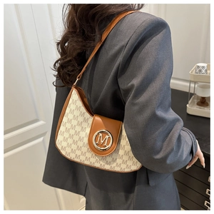 Detail of crescent shoulder bag featuring ivory canvas with brown leather and M-monogram