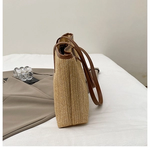 Détail du sac cabas en paille tressée avec texture à chevrons et bandoulière en cuir