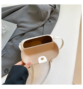 Close-up of white leather saddle bag interior featuring gold magnetic buckle closure