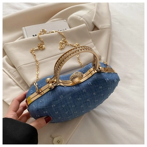 Close-up of blue denim evening bag with sparkling rhinestones and gold hardware