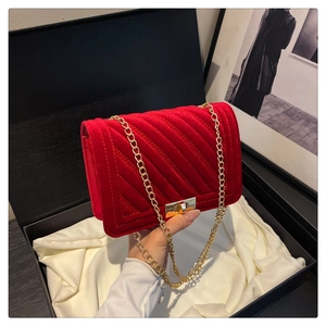 Dettaglio ravvicinato della borsa in velluto rosso trapuntato con catena d'oro e chiusura