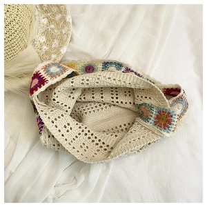Detailed overhead view of a crochet knit shoulder bag with bohemian daisy patterns