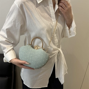 Mint green shell evening bag with white embroidery and golden circular handle