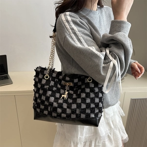 Chic checkerboard tweed tote bag with chain strap and deer charm on female model