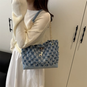 Contrast checkered denim tote bag with gold chain and tassel edge shown on model
