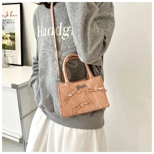 Détail du sac cabas rose avec nœuds perlés et bandoulière réglable pour femmes
