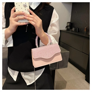 Détail du sac à main rose pailleté avec bandoulière en chaîne et texture de sequins