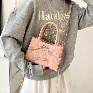 Sac à main plissé rose avec nœuds en perles et logo porté en bandoulière élégante