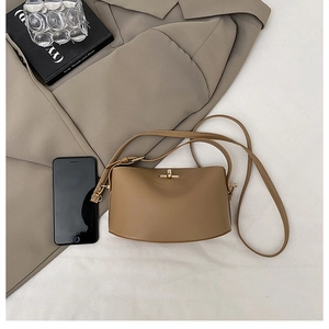 Detail of brown vintage crescent bag featuring golden twist lock and matte leather