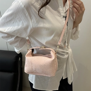 Chic pink snake-print crossbody bag with gold hardware worn over a white shirt