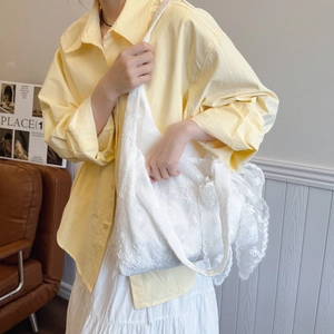 Sac cabas blanc en dentelle florale avec nœud et large bandoulière sur modèle