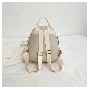 Detail of light beige backpack straps with premium black metal adjustment buckles