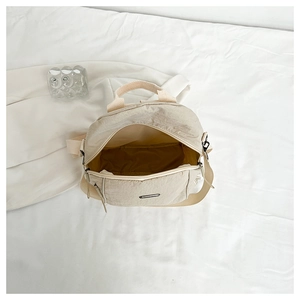 Top view of beige nylon mini backpack interior with zipper and spacious main compartment
