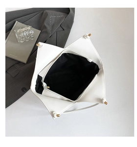 Close-up of white geometric tote interior with black lining and gold hardware