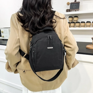 Minimalist black nylon backpack for women with metal logo for daily urban commuting