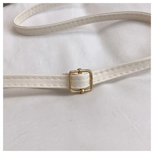 Vue macro de la bandoulière en cuir blanc avec coutures et boucle en métal doré