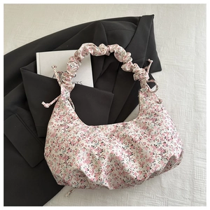 Détails du sac floral avec motifs roses et texture plissée sur la bandoulière