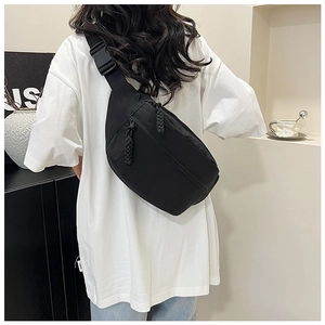 Vue arrière d'un mannequin portant un sac bandoulière en nylon noir avec sangle réglable