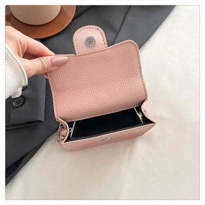 Pink lychee grain leather mini bag detail showing black lining and magnetic snap button