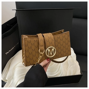Primer plano de bolso de hombro con monograma marrón, logotipo M dorado y detalle de cadena
