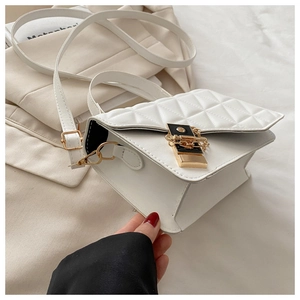 Detail of white quilted crossbody bag with gold-tone hardware and elegant metal chain lock