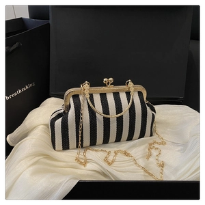 Detail of vintage black and white striped shell bag with gold metal frame and spherical clasp