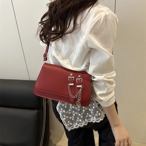Red retro underarm bag with decorative belts, silver chain, and adjustable strap for women