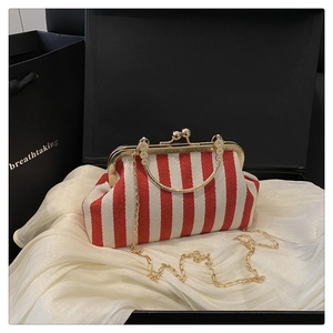 Detail of red and white striped shell bag with gold chain on white satin