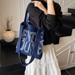 Street style dark blue denim tote bag with large letter patch and wide shoulder strap