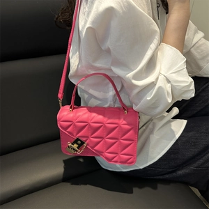 Chic magenta quilted square crossbody bag with gold hardware and geometric triangle pattern