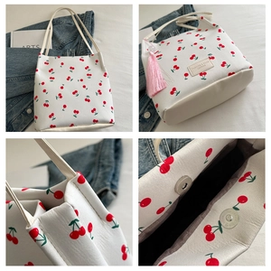 Detail van de shopper met kersenprint, roze kwastje en magnetische sluiting