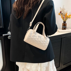 Sac cylindrique blanc crème avec matelassage en cœur et décoration de nœud