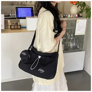 Detail of black pleated canvas tote bag with drawstring closure and mini coin purse