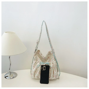 Detailed view of floral backpack with blue checkered bow and side elastic pockets