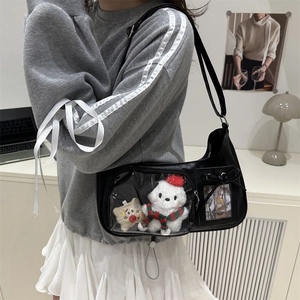 Fashionable black transparent PVC crossbody bag with plush bear inside on aesthetic desk