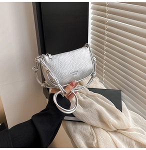 Détail du sac argenté avec texture litchi et bandoulière à nœud unique pour femme