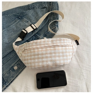 Détail du sac banane à carreaux avec broderie ondulée et téléphone pour la taille