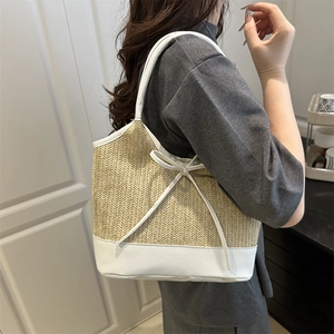 Women's woven straw beach tote bag with white leather trim and bow detailing