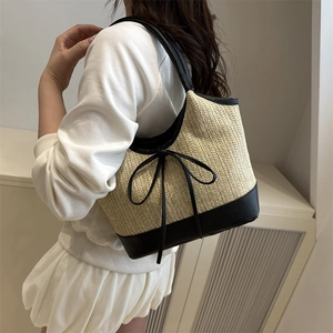 Large woven beach tote bag with black leather straps and elegant bow accent