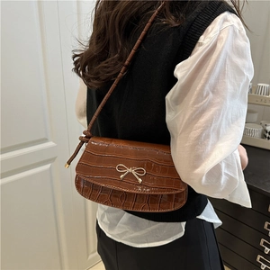 Brown crocodile pattern shoulder bag with golden bow clasp and stylish knot strap detail