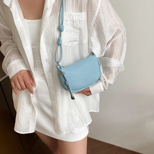 Sac bandoulière chic bleu clair avec texture litchi et bandoulière nouée élégante