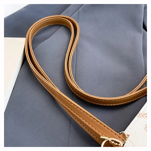 Détail de la bandoulière en cuir marron avec surpiqûres blanches et motif animalier orange