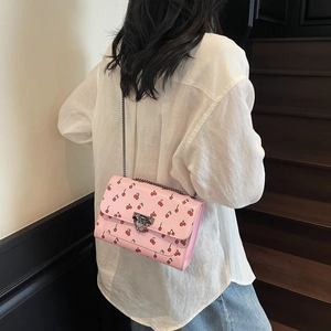 Sac bandoulière rose avec imprimés cerises et chaîne argentée style estival